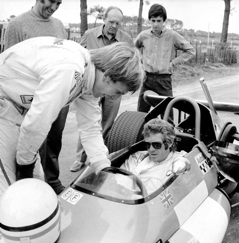 Famous US movie star Steve McQueen (1930-1980) (The Great Escape, Bullit) at the wheel of a Brabham F2, at Le Mans 18 July 1970, listens to British Formula 1 pilot Derek Bell who is giving him some advice. Steve McQueen is in Le Mans to act as a pilot in the Preston Sturges' s film "Le Mans". (Photo credit should read STAFF/AFP/Getty Images)
