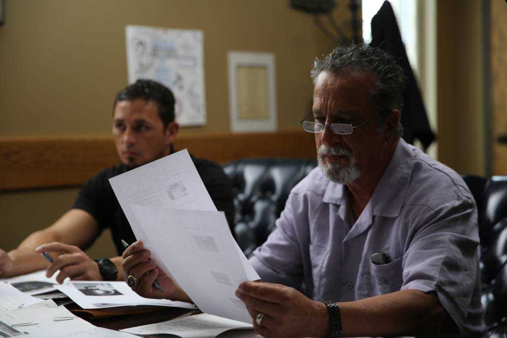 Retired Detective Rhodes Sanchez and Detective Aubrey St. Angelo looking at notes.