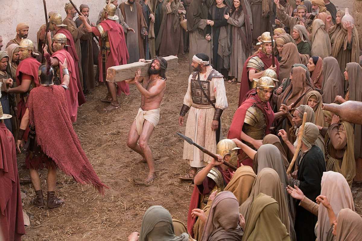 Haaz Sleiman as Jesus, carries the cross through the streets of Jerusalem.  (photo credit:  National Geographic Channels/Kent Eanes)